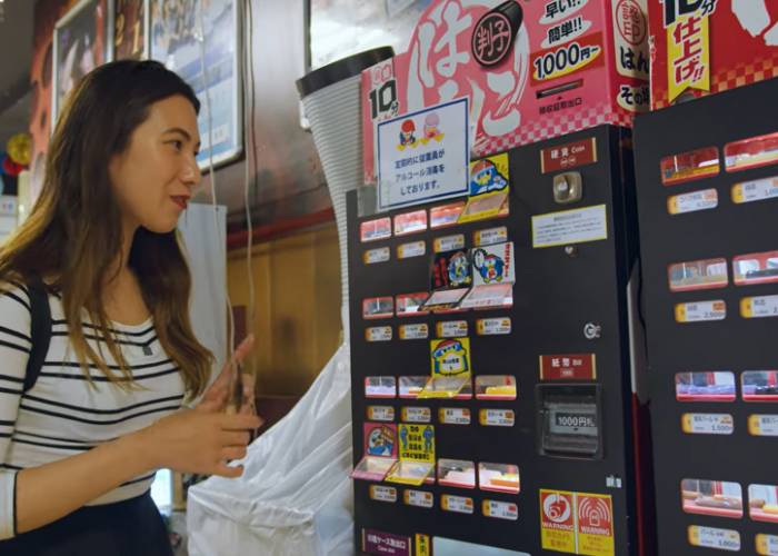 Shizuka looking at the options on a hanko stamp seal vending machine.